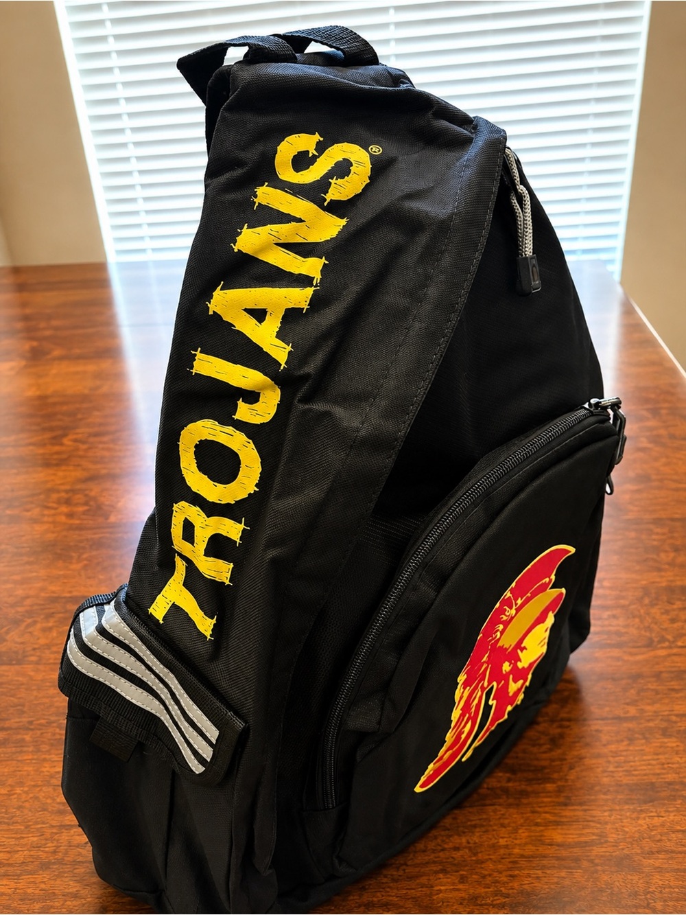 Black Trojans Sling Backpack with Yellow Logo and Red Accent